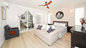 Un salón espacioso con sofá, cama, ventilador de techo y mesa de comedor.