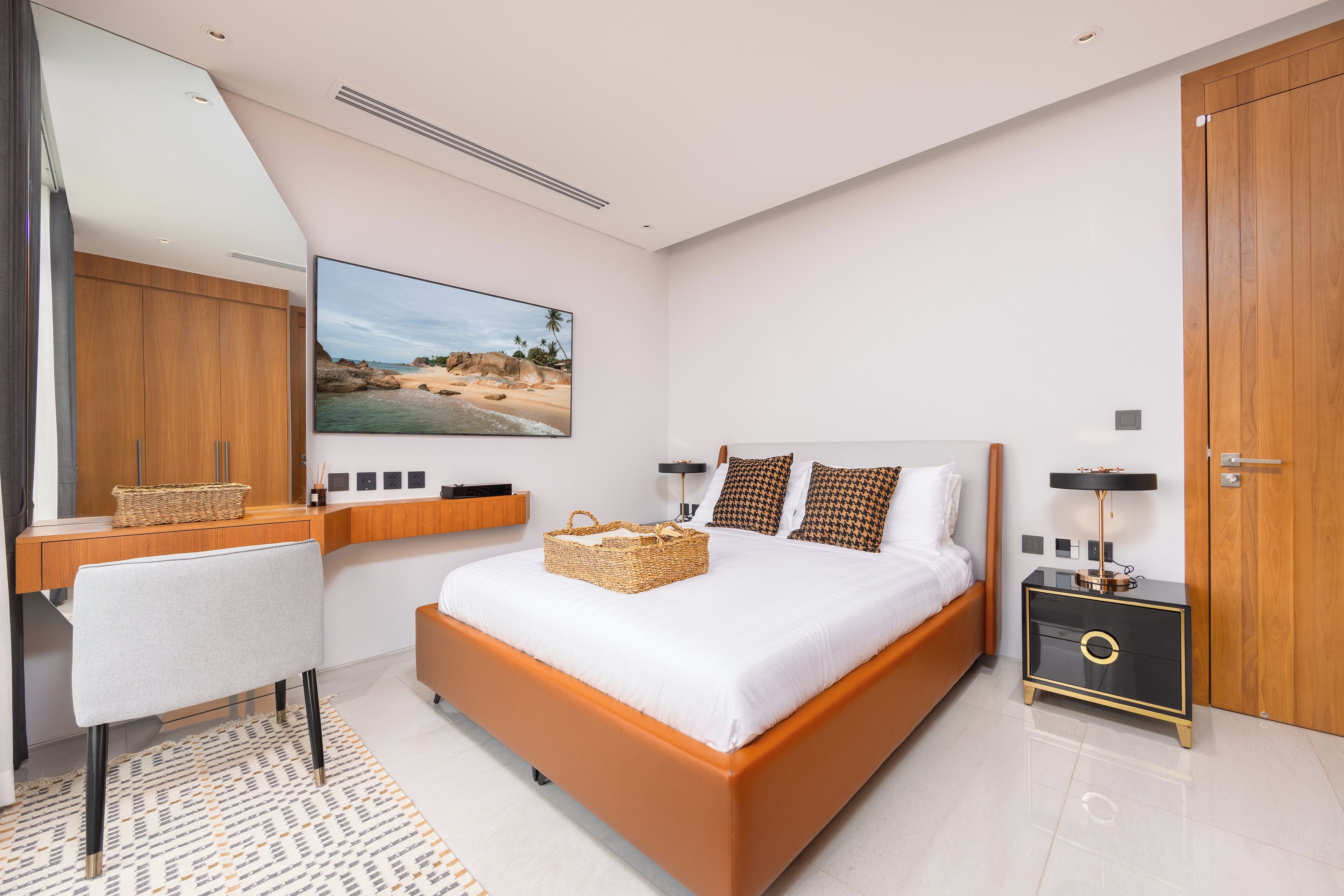 Quarto moderno com uma cama grande, uma escrivaninha e uma mesa de cabeceira.