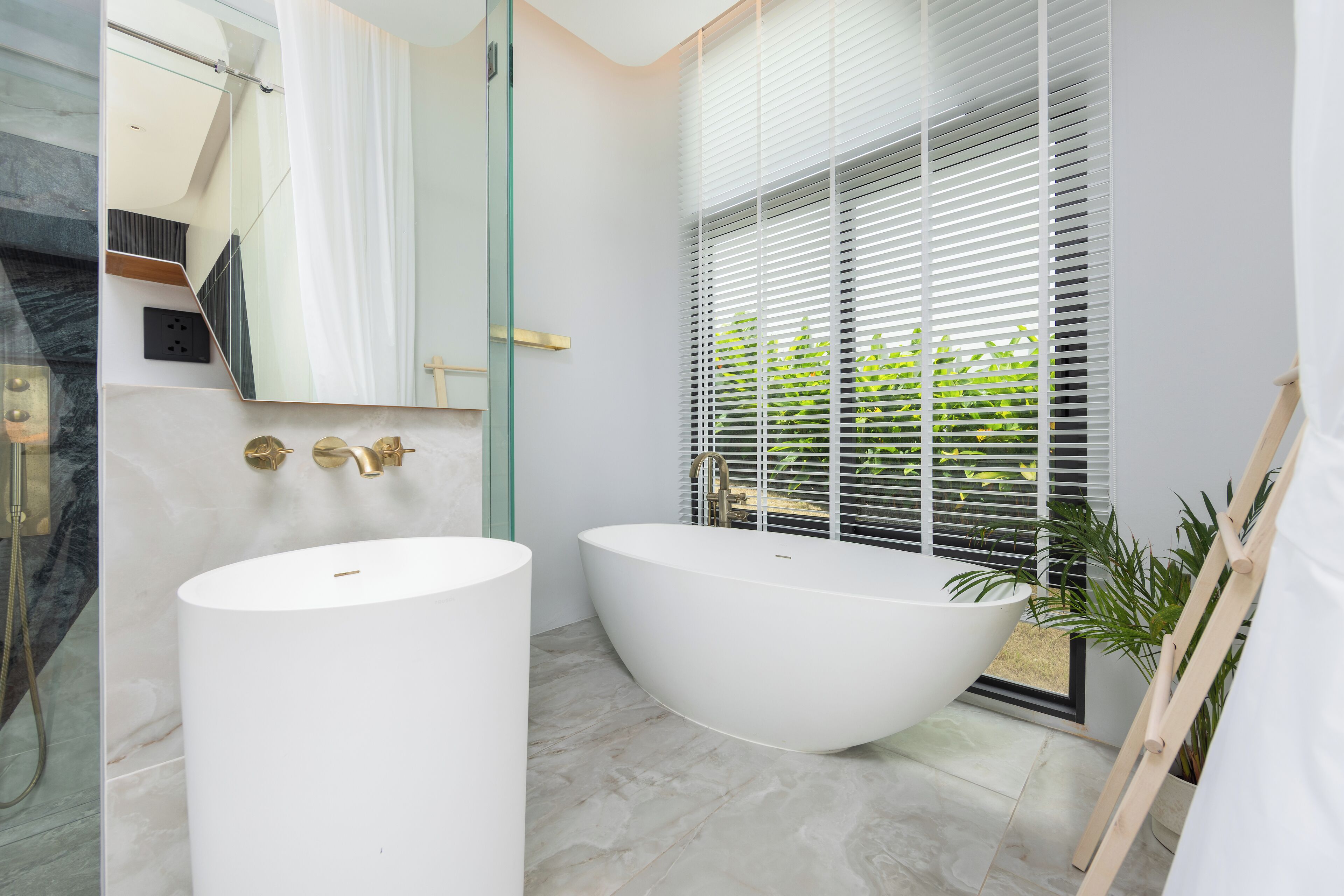 Ein modernes Badezimmer mit einer freistehenden Badewanne, einem großen Spiegel und einer Duschkabine.