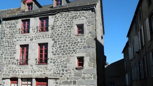 A stone building with red shutters and a car parked in front. - La Maison De Marie: Renaissance-Style Holiday Home with Private Terrace and Wi-Fi (Murat)