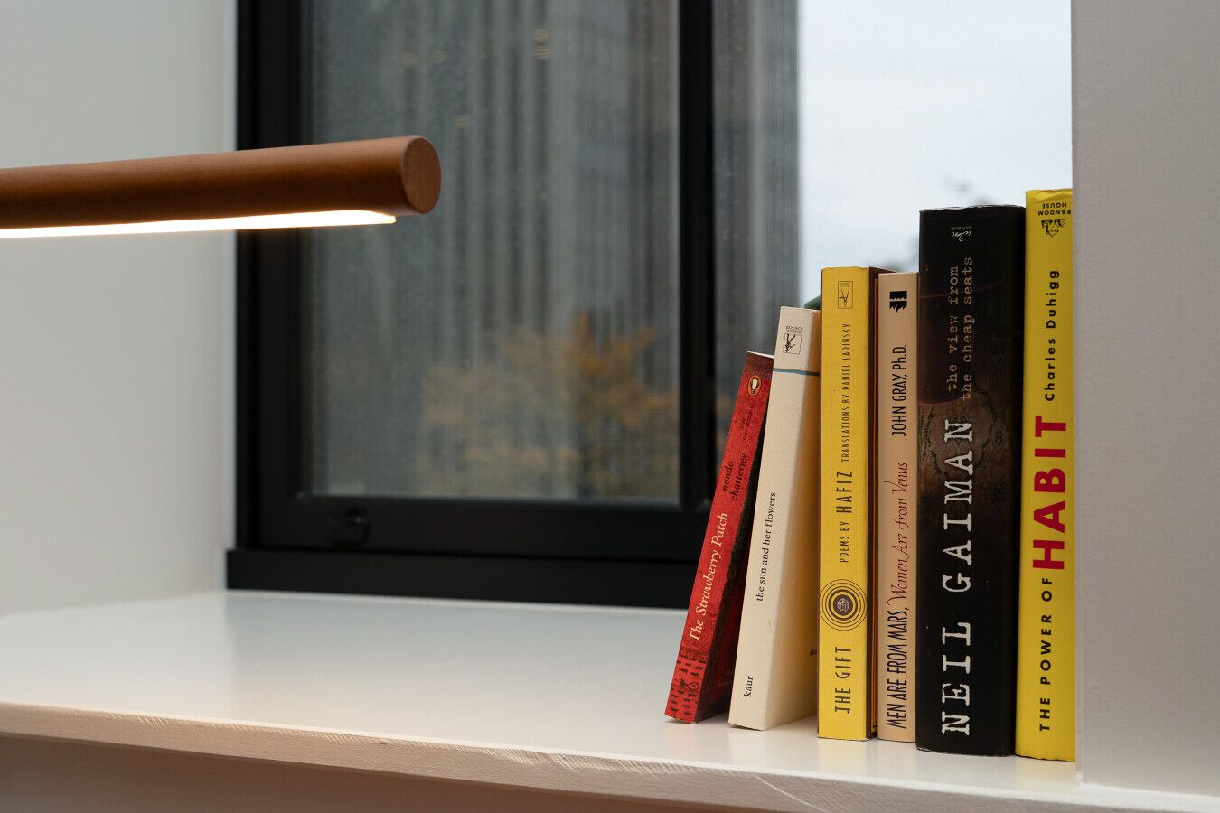 A bookshelf with books and a lamp.