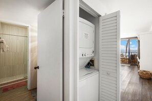 A laundry room with a dryer, a washing machine, and a door leading to a balcony with a view. - Upgraded Corner Unit with Amazing Pool and Ocean Views! - Sugar Beach #421 (Kihei, Maui)