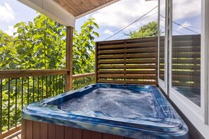 A hot tub on a wooden deck with a view of green foliage and a wooden fence. - Amazing Views Hot Tub Arcade Firepit (Gatlinburg)