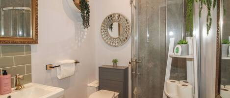 Une salle de bain avec des toilettes, un lavabo et une douche.