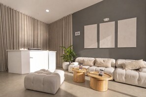 A modern living room with a sofa set, two wooden side tables, a white console table, and a large potted plant. - Modern 2BR/2AC Apt- Jacuzzi`s, Cowork, Sauna & GYM (Medellín)
