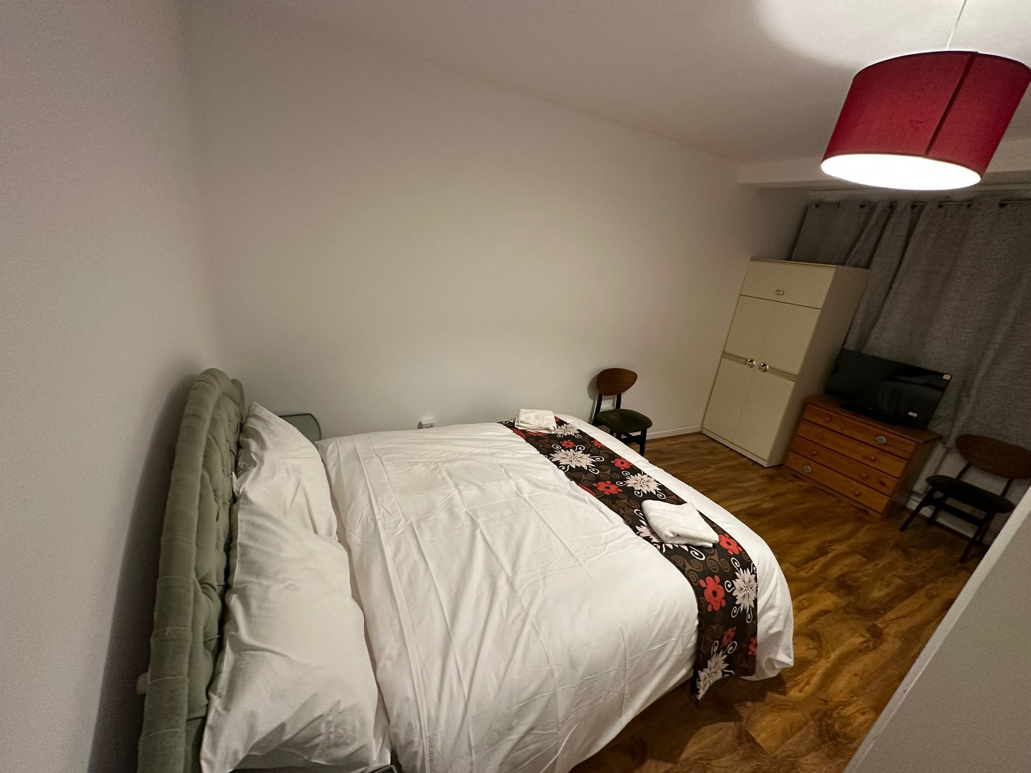 Makuuhuone, jossa on sänky, vaatekaappi, työpöytä ja tuoli.
