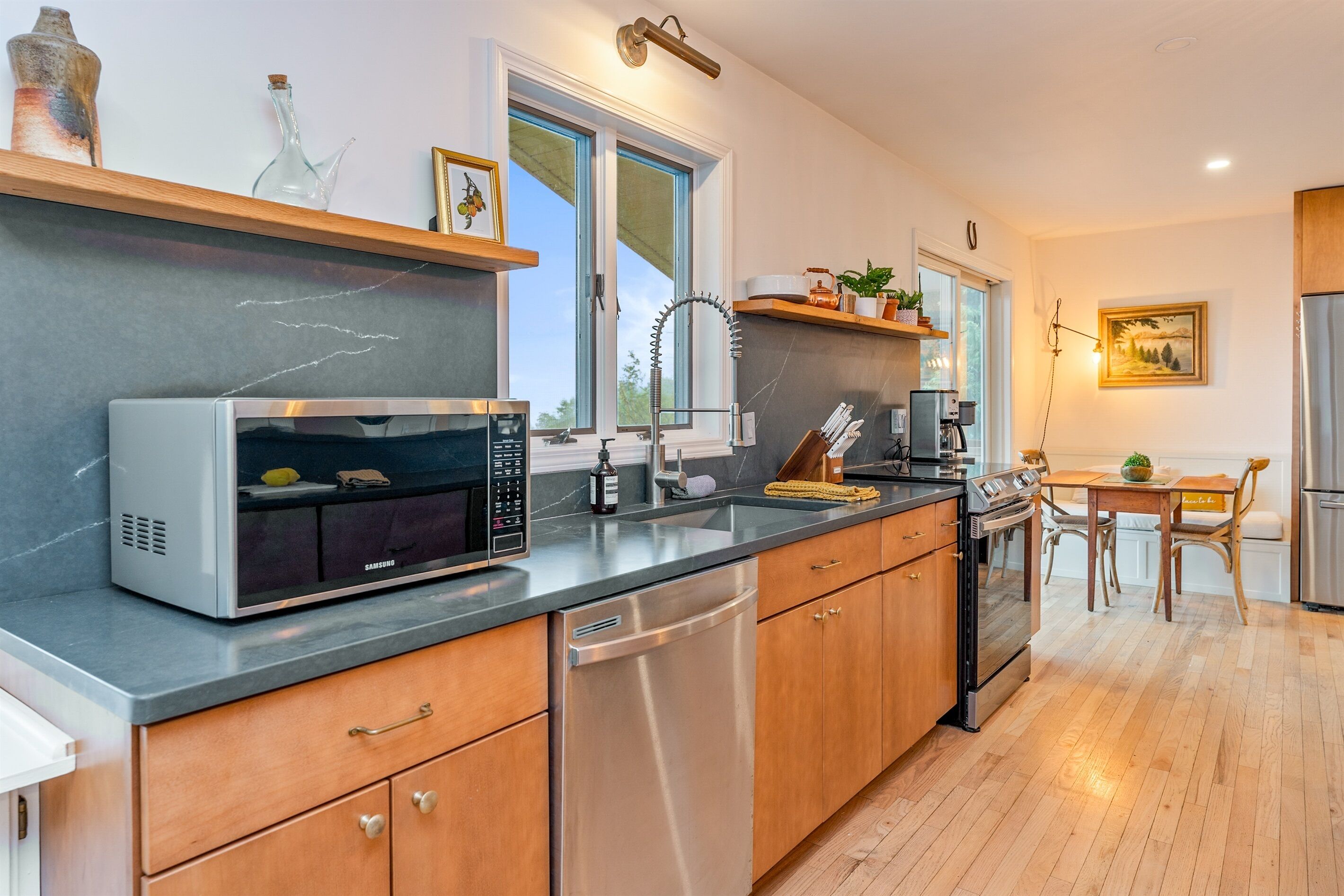 A modern kitchen with a built-in microwave, stainless steel dishwasher, and wooden cabinets.