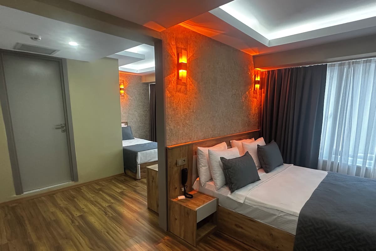 Family Triple Room, Balcony, Garden View | In-room safe, desk, soundproofing, iron/ironing board