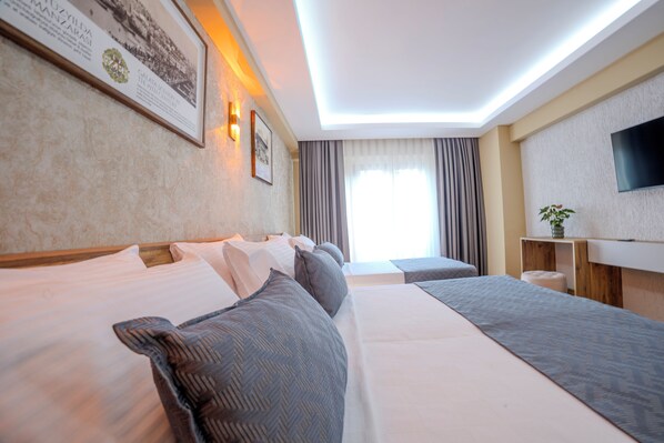 A hotel room with a large bed, a desk, and a flat-screen TV.