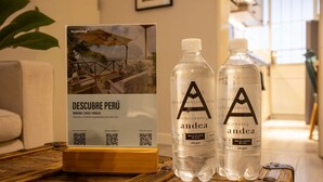 A promotional display with a sign for 'DESCUBRE PERÚ' featuring a QR code, two bottles labeled 'andea', and a wooden table. - Lovely 1BR in Miraflores (Lima)