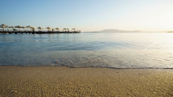 Plajda, beyaz kum, ücretsiz plaj kabini, şezlong