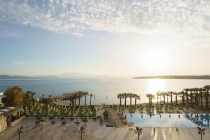 A resort with a pool, palm trees, and a view of the sea. - Boyalık Beach Palms Hotel (Cesme)