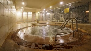 A hot tub area with a stone wall and lounge chairs. - Boyalık Beach Palms Hotel (Cesme)