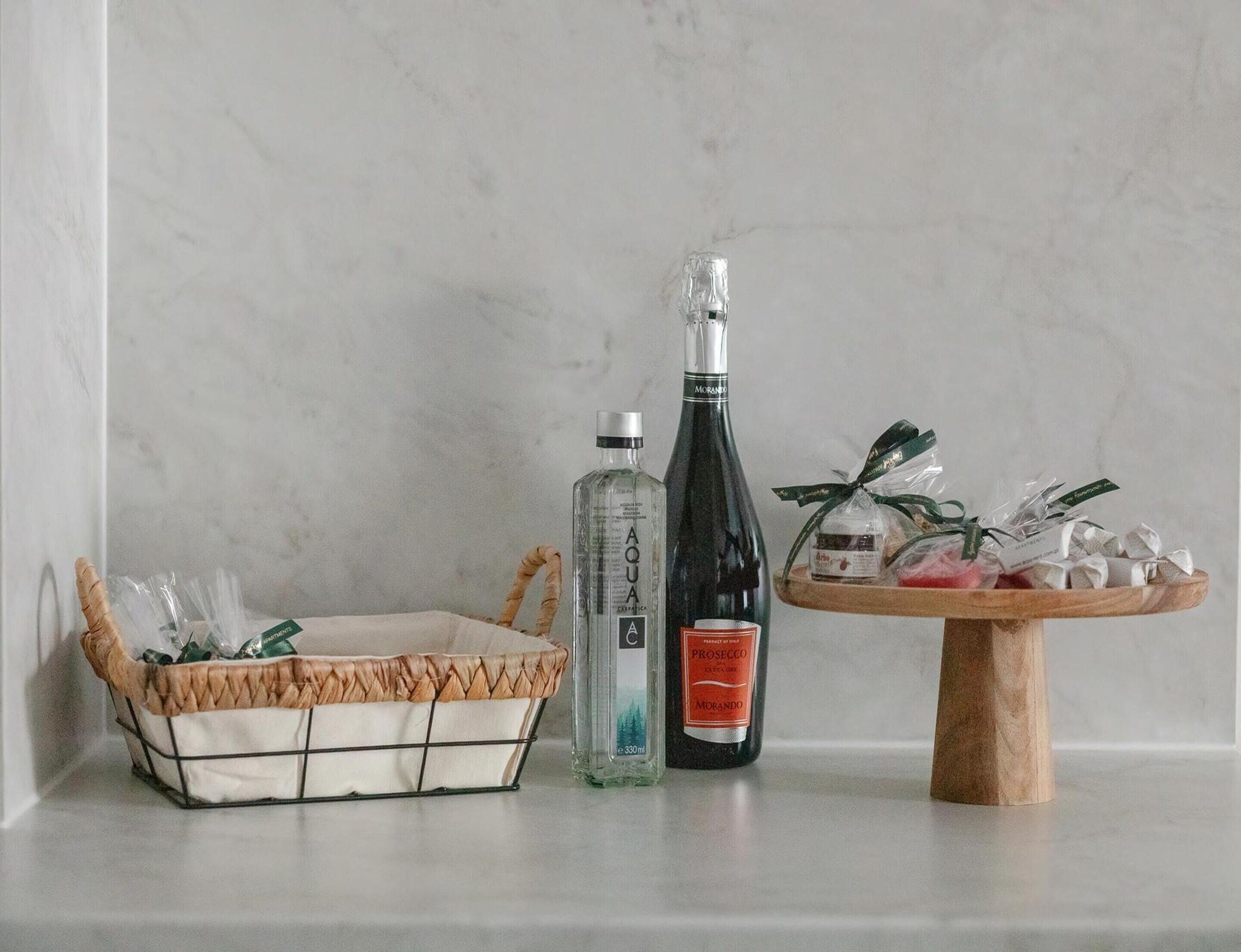 A wicker basket, two bottles, and a wooden stand with wrapped items.