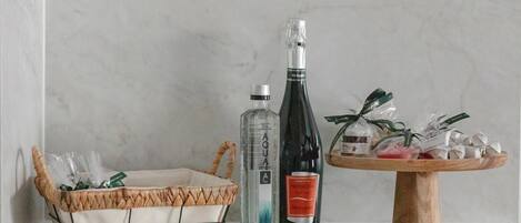 A wicker basket, two bottles, and a wooden stand with wrapped items.