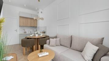 Una sala moderna con sofá, mesa de centro y comedor con sillas.