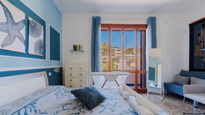 Habitación de hotel con cama, escritorio, silla y vistas al exterior.
