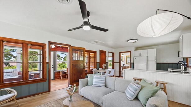 A spacious living area with a large sofa, a dining table, and a kitchen area.