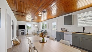 Eine moderne Küche mit Holzboden, weißen Wänden und grauen Schränken.