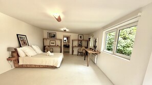 Ein Schlafzimmer mit einem Bett, einem Schreibtisch und einem Fenster.