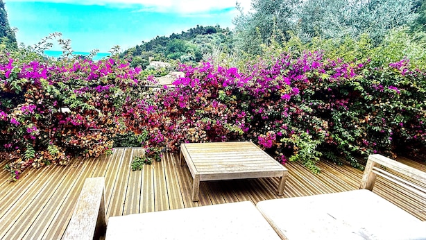 A wooden deck with a table and benches, surrounded by vibrant pink flowers and greenery. - Spectacular4-bedroom Villa- Private Pool, Sea Views and TropicalGardens. (Menton)