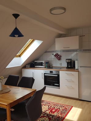 A kitchen with a skylight, a microwave, an oven, and a refrigerator. - Holiday Apartment 'Wolf' with Private Terrace, Shared Garden & Wi-Fi (Nietwerder)