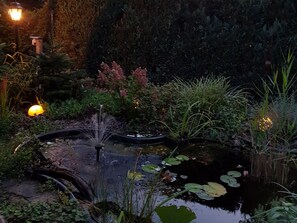 A garden with a pond, a fountain, and various plants. - Holiday Apartment 'Wolf' with Private Terrace, Shared Garden & Wi-Fi (Nietwerder)