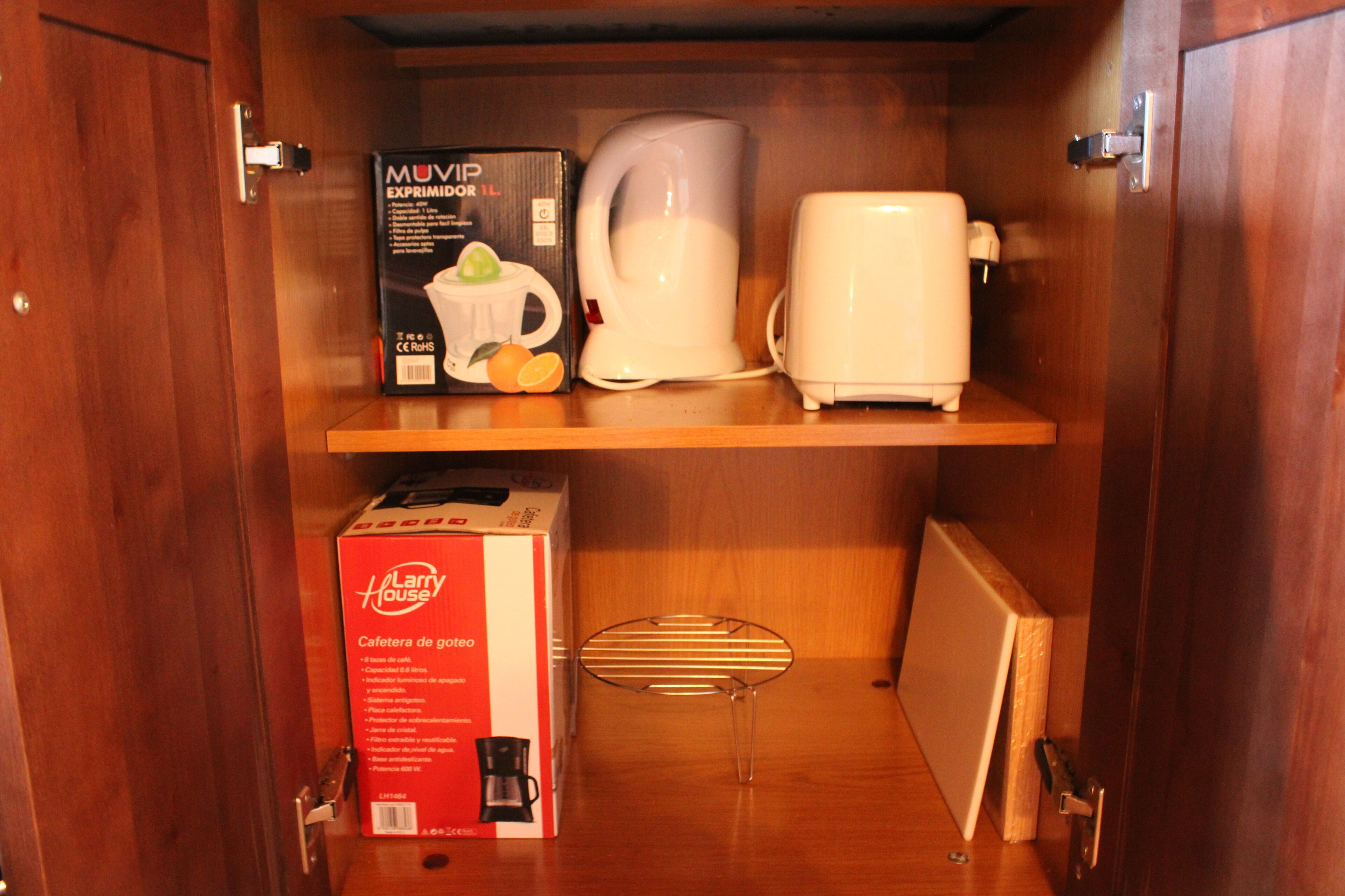 Un meuble en bois contenant une machine à café, une boîte étiquetée « Maison de Larry » et un four à micro-ondes.