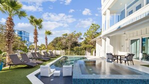 A modern pool area with lounge chairs, a small pool, and a dining area.