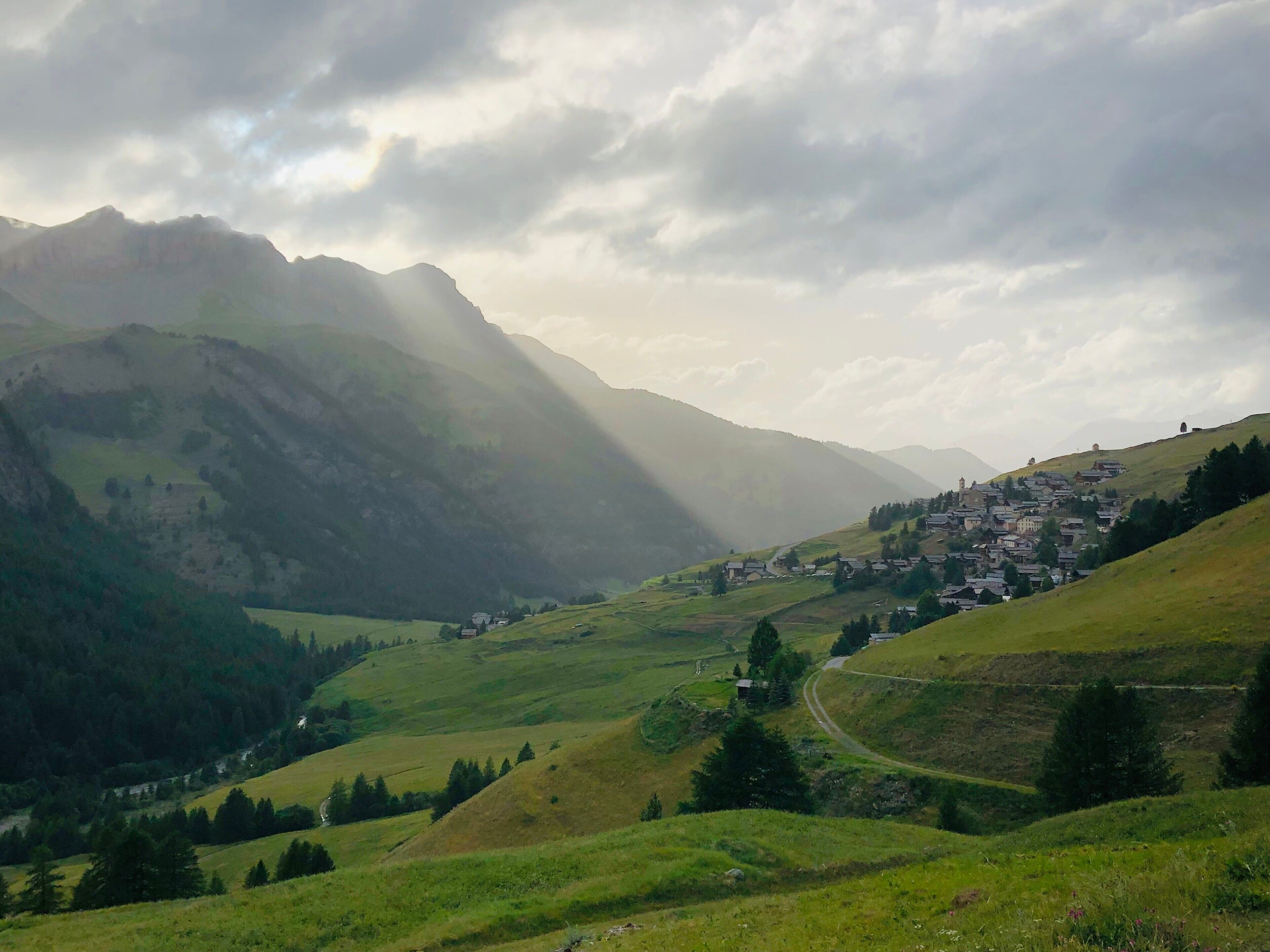 Un paisaje montañoso con un pueblo ubicado en el valle.