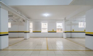 Amplio espacio interior bien iluminado, con pisos de baldosas y paredes blancas, que presenta franjas amarillas y negras en los bordes.