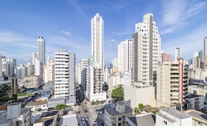 A high-rise urban area with multiple buildings, including a prominent tall white building and several shorter residential structures. -  Apartment with bathtub near the beach YVD1301 (Balneário Camboriú)