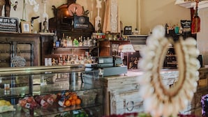 A bar area with a display case of fruits and a sign indicating WiFi password. - House of Mosaic Aruba - Unique Experience (Oranjestad)