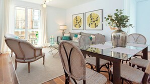 A dining area with a glass table, wicker chairs, and a vase with flowers. - Luxury Apartment in Cadiz Center. San Antonio IV (Cádiz)