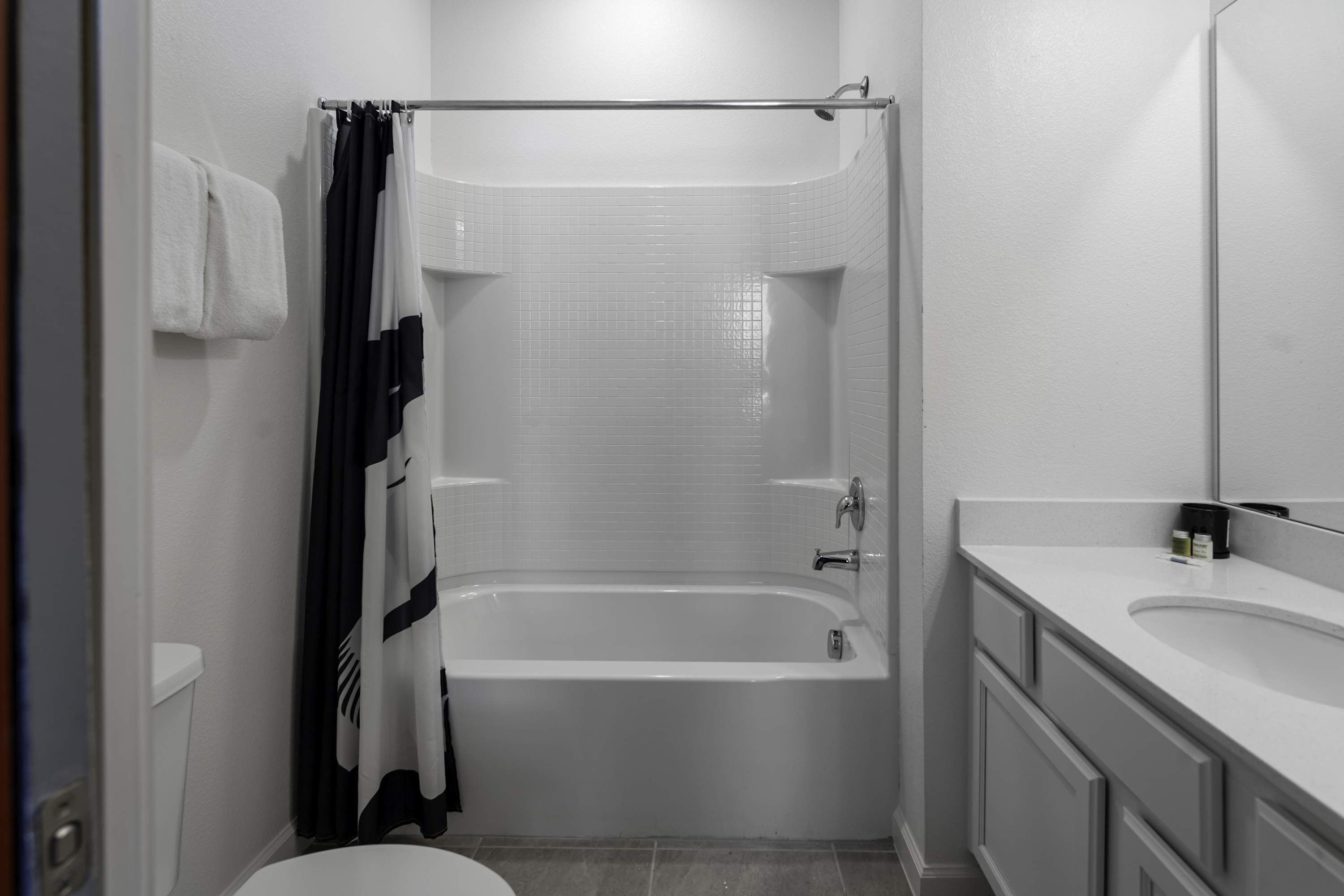 A bathroom with a bathtub, a toilet, and a sink.