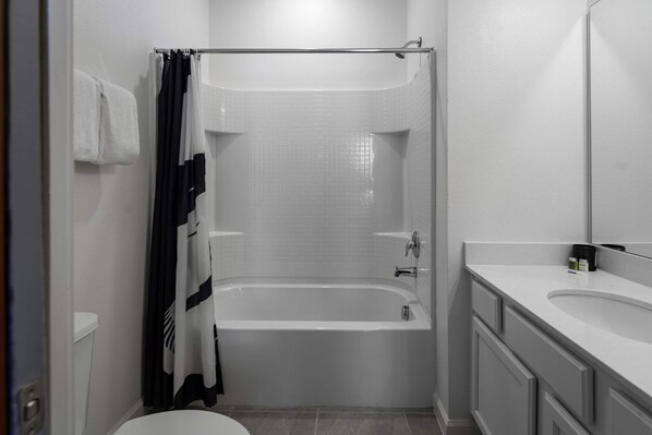 Un baño con bañera, inodoro y lavamanos.