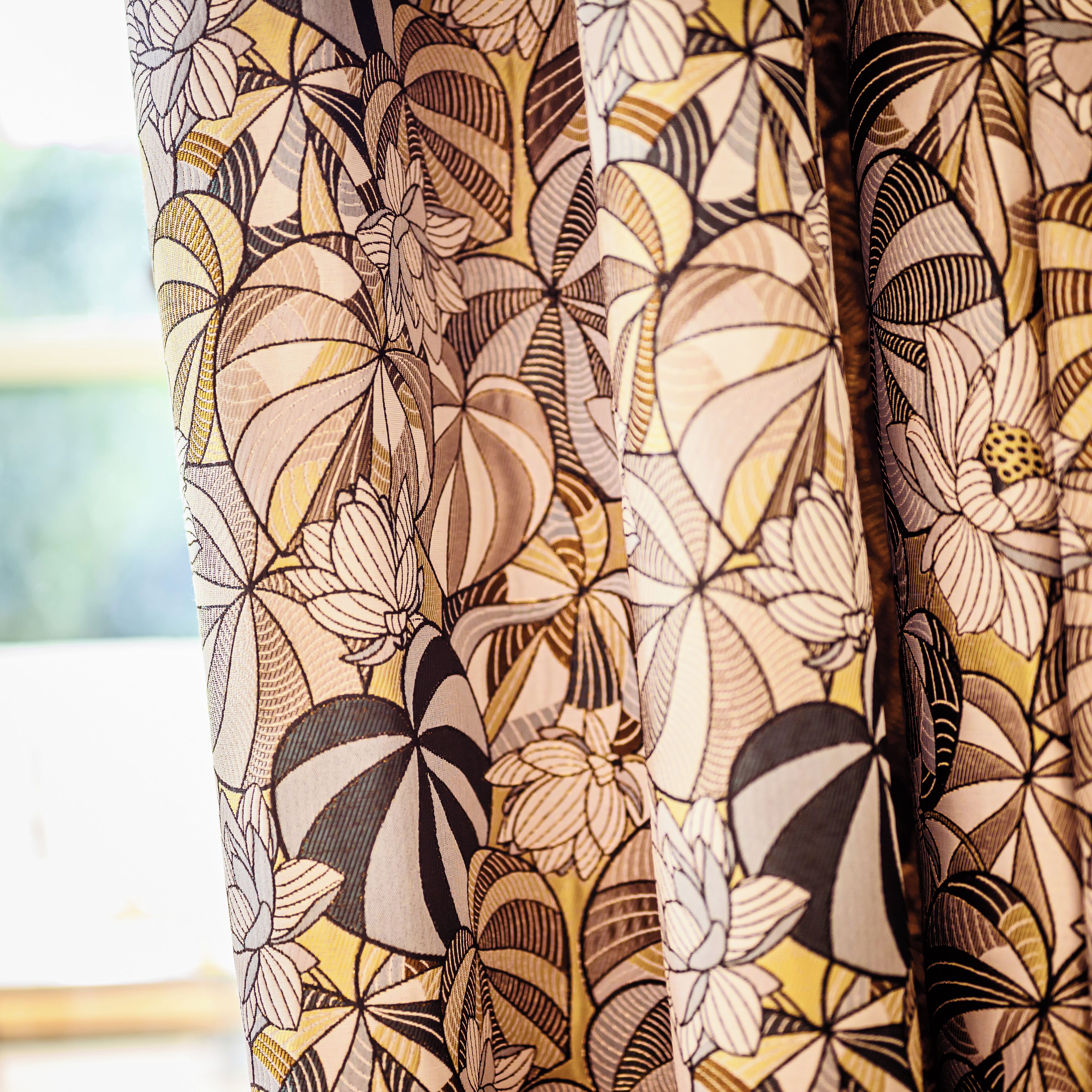A close-up of a curtain with a floral pattern.