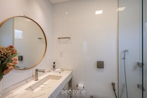 A modern bathroom with a large mirror, a sink, and a shower area. - 3br Apt Sea View BBQ Garage - BC Vld1002 (Balneário Camboriú)