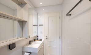 A modern bathroom with a large mirror, a white sink, and a door. - 3br Apt Sea View BBQ Garage - BC Vld1002 (Balneário Camboriú)