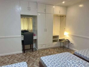 A room with a bed, a desk, and a wardrobe.
