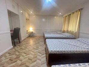 Una habitación con dos camas, un escritorio y una silla.