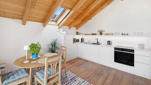 A modern kitchen with white cabinets, a black oven, and a skylight. - Apartment 'Monte Fiori' with Balcony and Wi-Fi (Anzing)