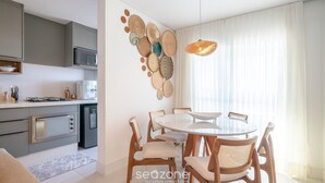 Cocina moderna con microondas, estufa y refrigerador. Cuenta con un comedor con mesa redonda y sillas.
