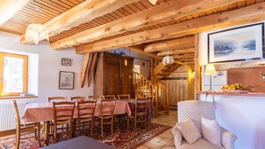 Un intérieur en bois comprenant un coin repas, un escalier et un bar.