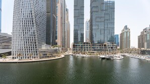 A marina with boats docked, surrounded by modern high-rise buildings. - Serene 1BR at Iris Blue Marina (Dubai)