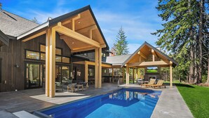 A modern house with a large pool, outdoor seating, and a stone fireplace. - Private Pool * Fantastic Outdoor Living in Suncadia! (Cle Elum)