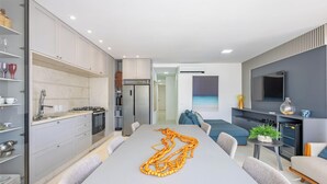 A modern kitchen with grey cabinets, a dining table, and a long orange beaded necklace. - 3-suite apt 280m From sea in Itapema Vga1002 (Itapema)