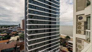 Un edificio alto con varios pisos, amplias ventanas y vista al mar.