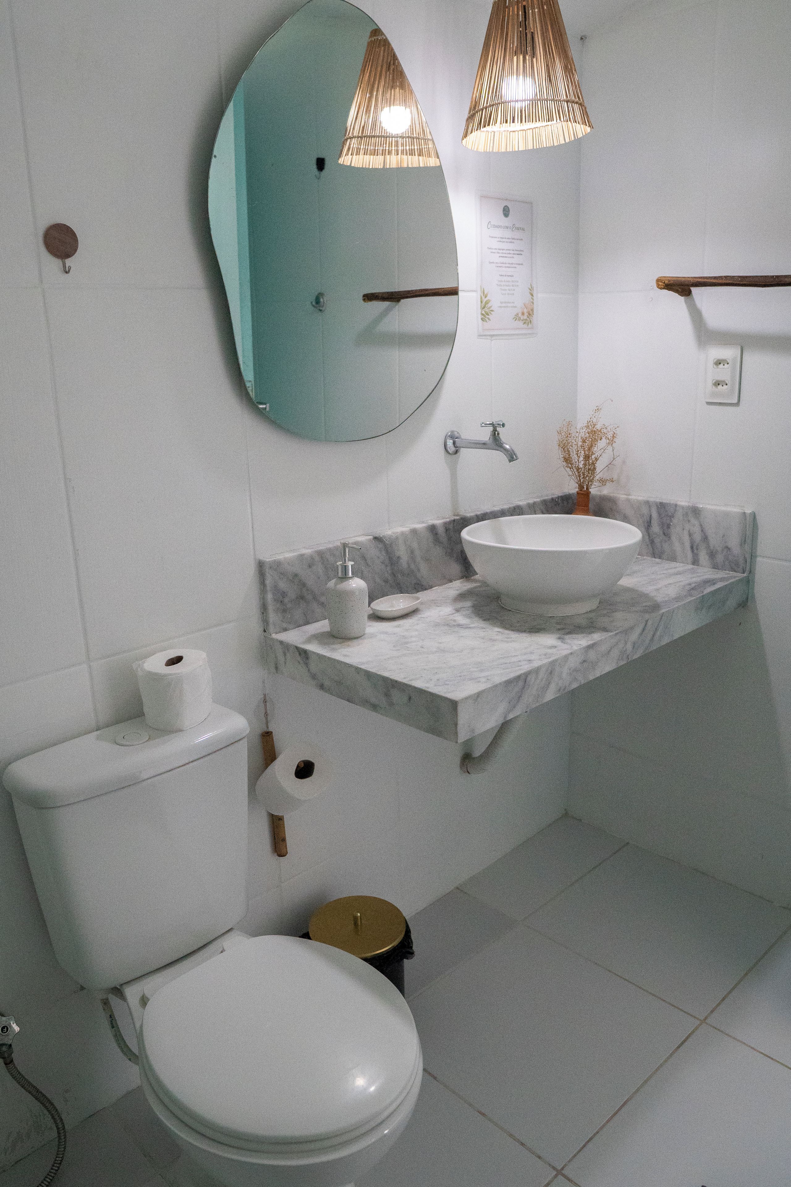 Ein Badezimmer mit Toilette, Waschbecken, Spiegel und Handtuchhalter.