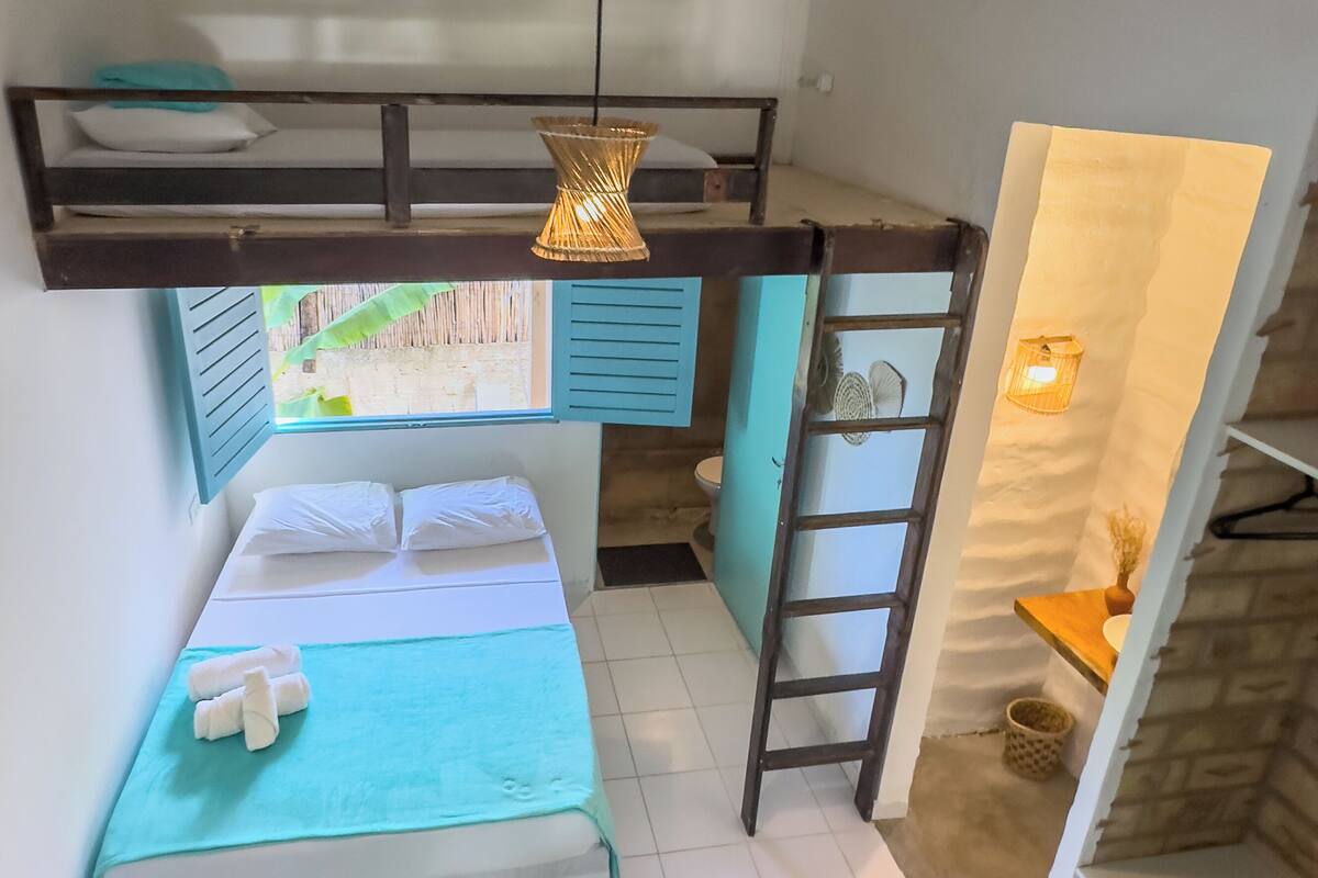 A compact room with a bunk bed, a desk, and a ladder.